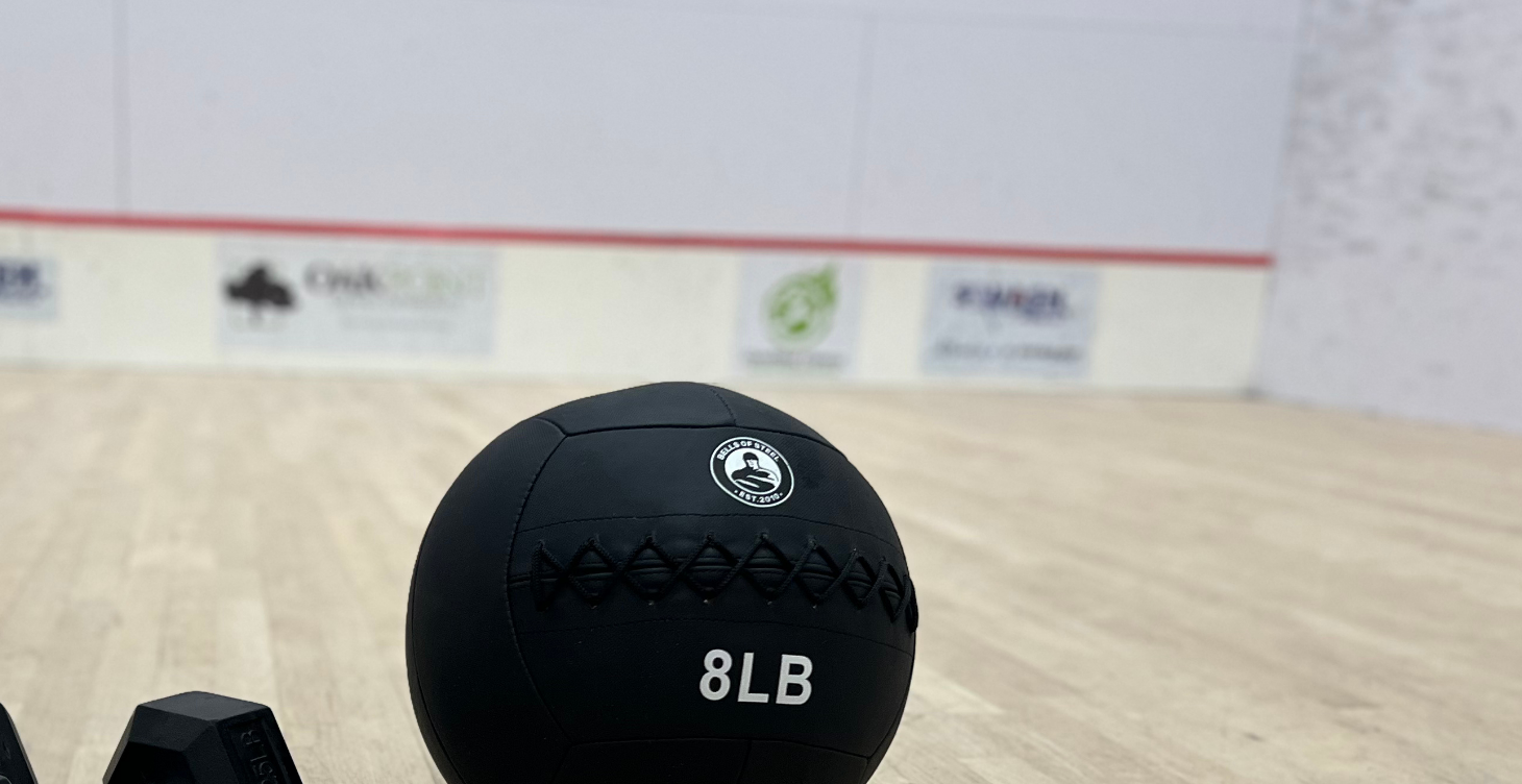 Medicine ball and dumbbells on a squash court